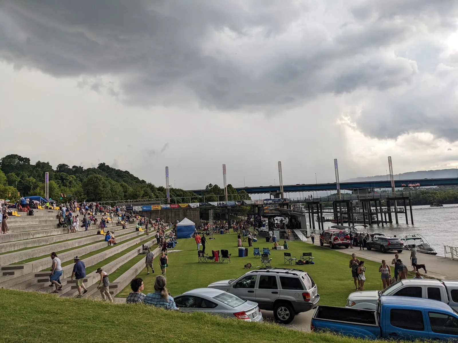 Ross's Landing riverfront park on the Chattanooga Riverwalk with terraced lawn steps and storm clouds over the Tennessee River